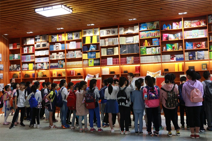 小读者参观市图书馆一楼大厅书墙.jpg
