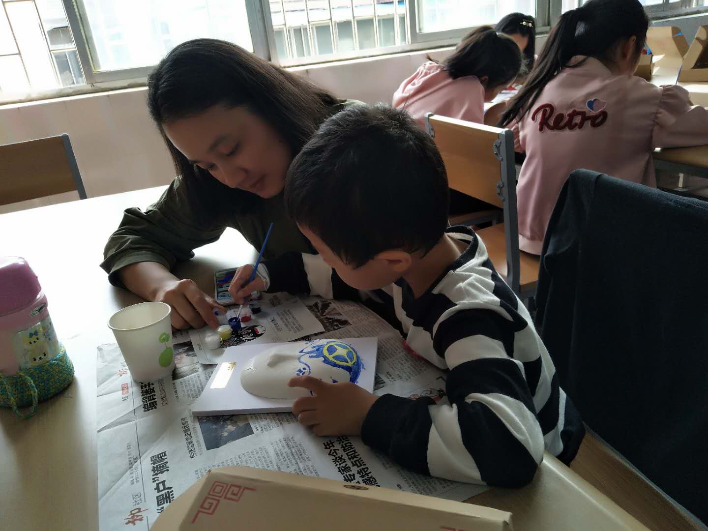 老师指导孩子绘制脸谱.jpg
