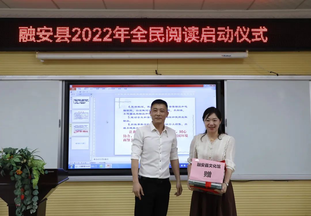 4月25日，在融安县2022年“绿书签行动”进校园暨全民阅读启动仪式现场，融安县文化馆（左）向县实验二小（右）赠送书籍。（杨雯静 摄）.jpg