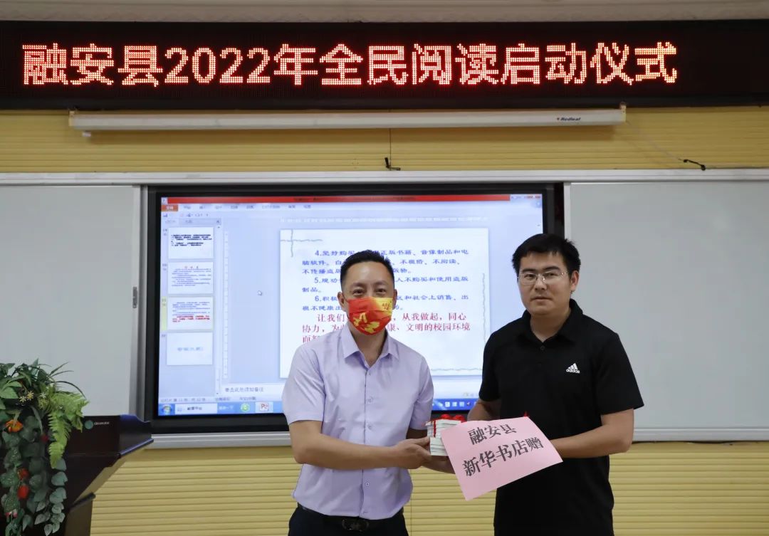 4月25日，在融安县2022年“绿书签行动”进校园暨全民阅读启动仪式现场，融安县新华书店（左）向县实验二小（右）赠送书籍。（杨雯静 摄）.jpg