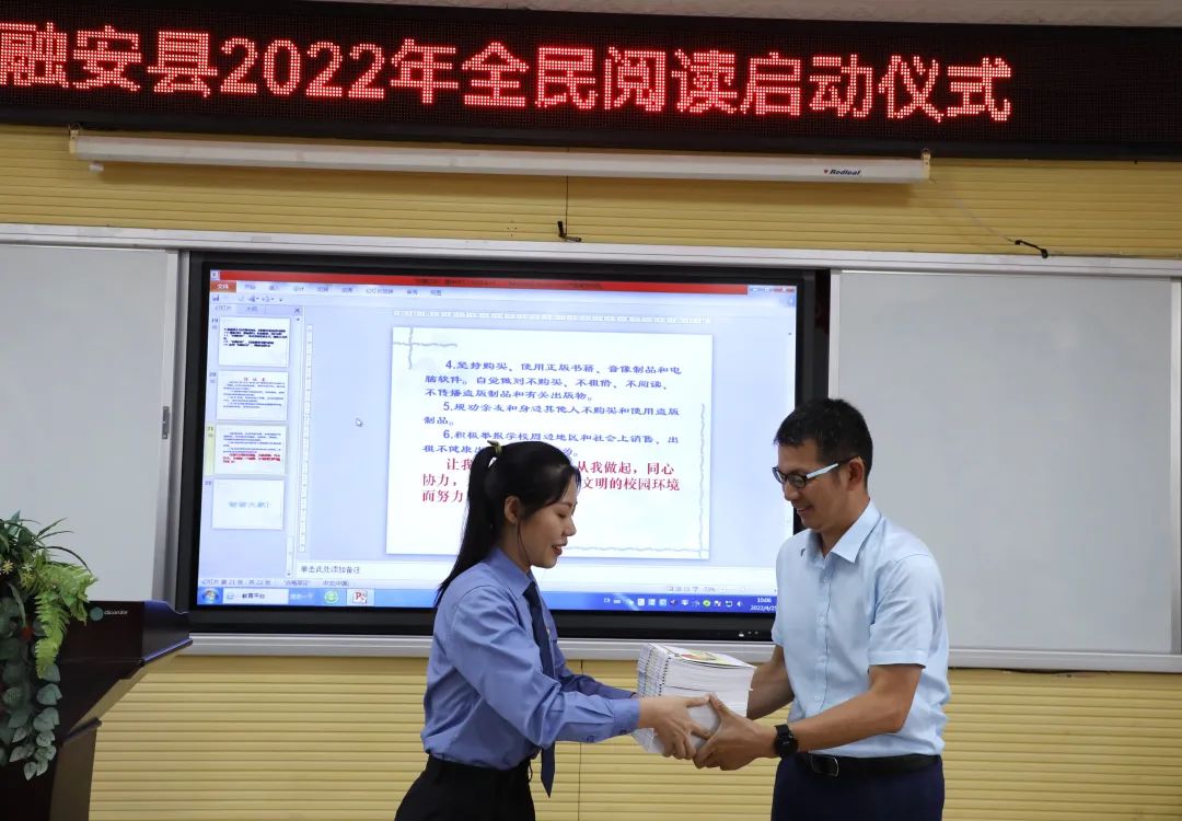 4月25日，在融安县2022年“绿书签行动”进校园暨全民阅读启动仪式现场，融安县检察院（左）向县实验二小（右）赠送书籍。（杨雯静 摄）.jpg